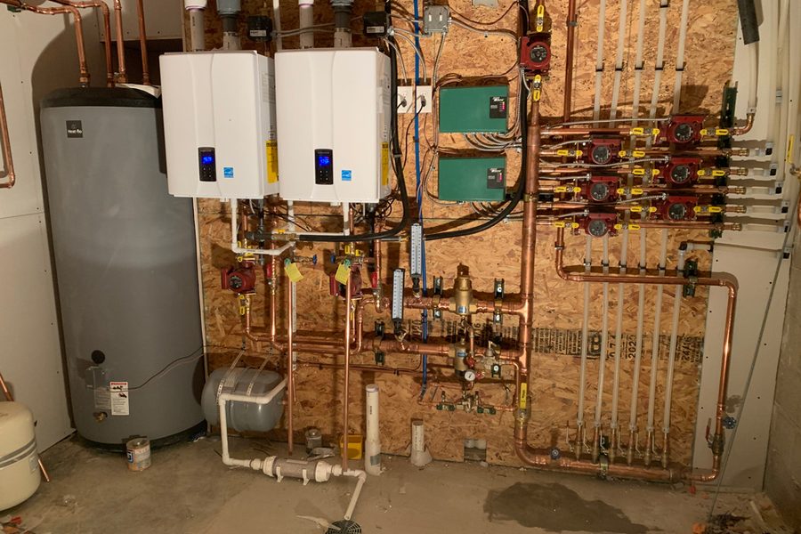 Two wall hung condensing boilers with a copper circulator manifold
